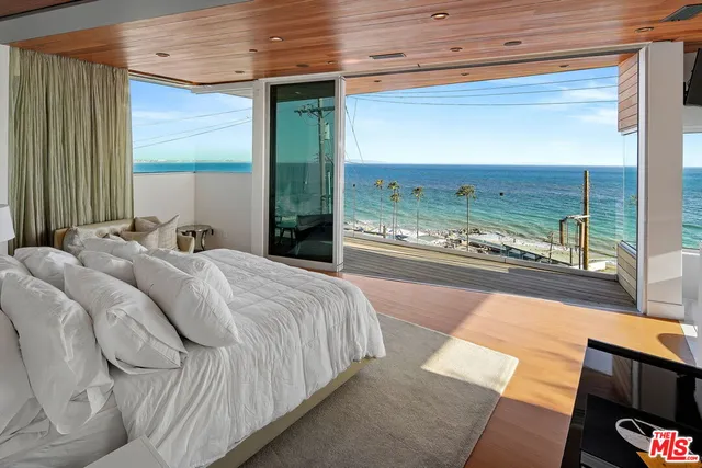 a bedroom with a bed and view of living room