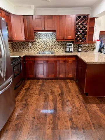 a kitchen with stainless steel appliances kitchen island granite countertop a stove a sink and a microwave