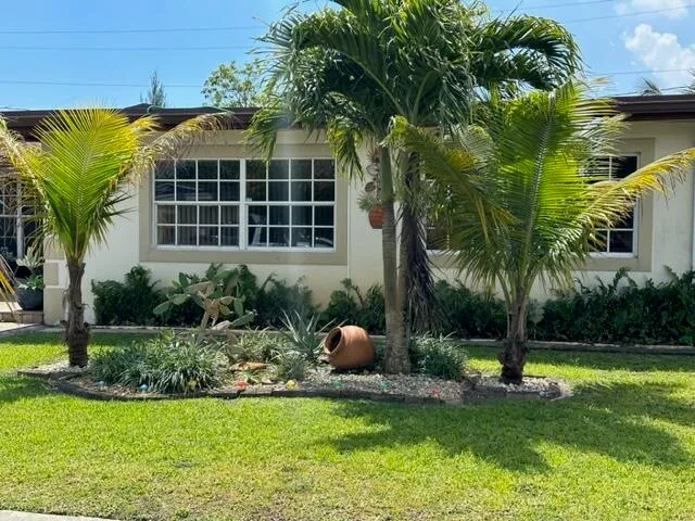 a front view of multi story residential apartment building with yard and green space