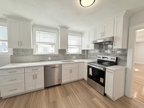 a kitchen with granite countertop white cabinets and white appliances