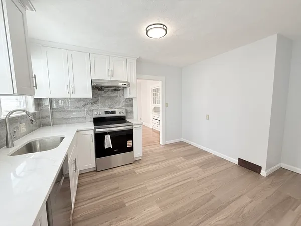 a kitchen with granite countertop a sink and a stove top oven