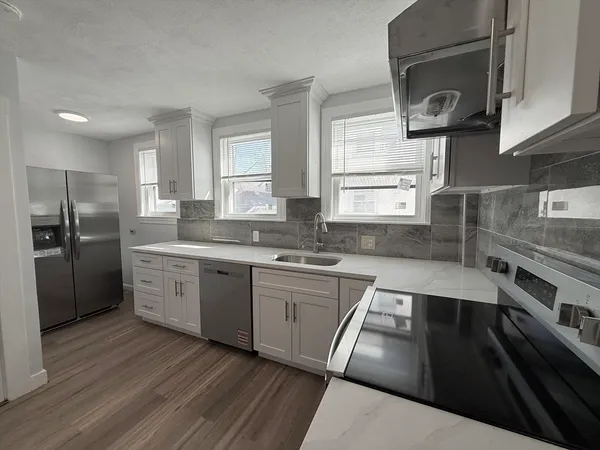 a kitchen with a sink dishwasher a stove and a refrigerator