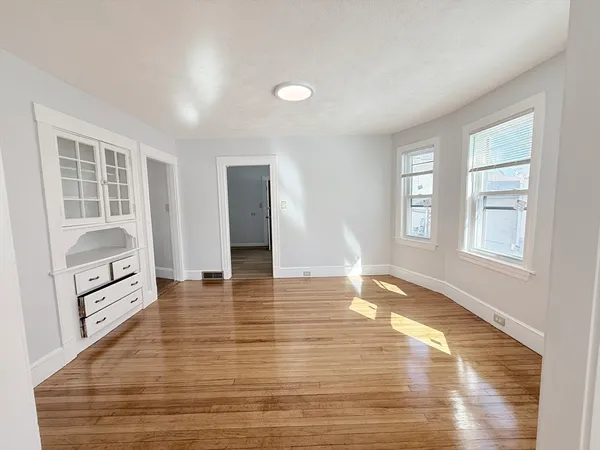 an empty room with windows and wooden floor
