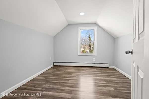 a view of an empty room with wooden floor