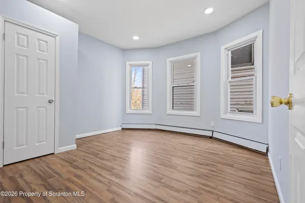 wooden floor in an empty room with a window