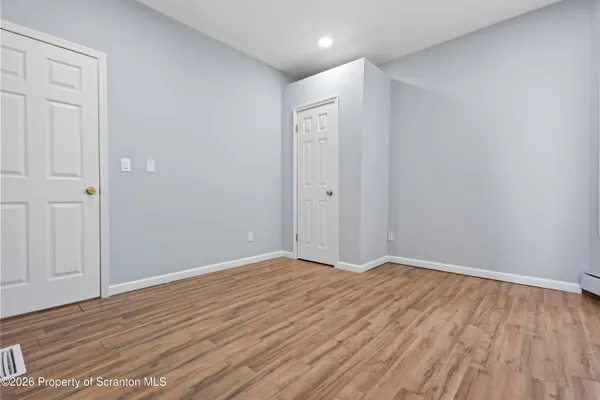 a view of a room with wooden floor and window