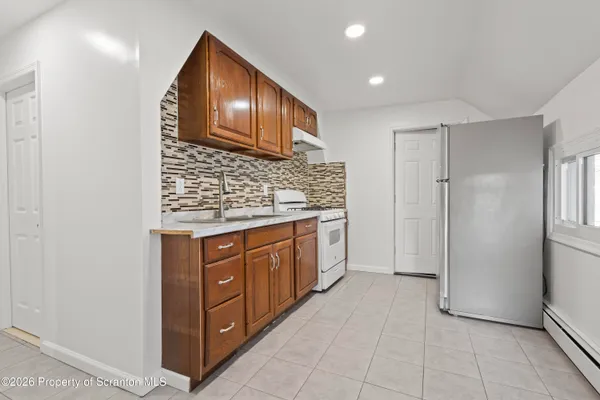 a kitchen with granite countertop white cabinets and white appliances