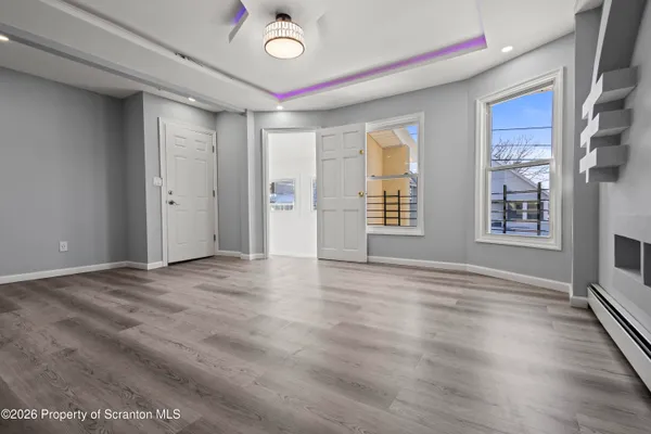 a view of a big room with wooden floor and windows