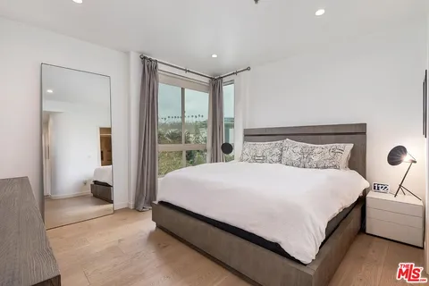 a large bed sitting in a bedroom next to a window