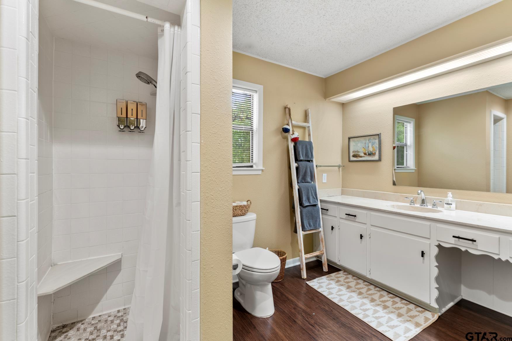 1614 County Road 2600 Mount Pleasant, TX 75455 - Photo 13 of 27 a bathroom with a toilet a sink and mirror
