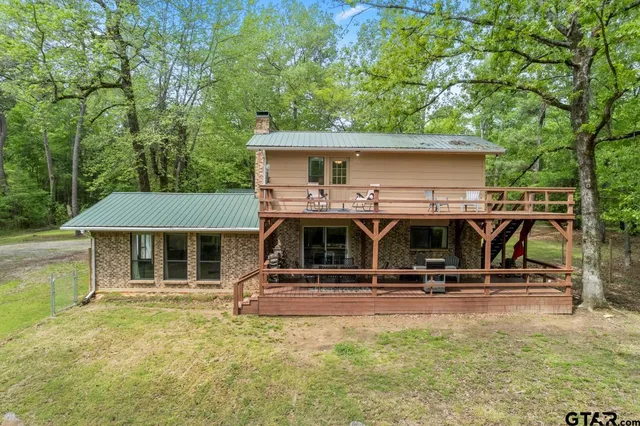 a view of a house with pool table and chairs under an umbrella