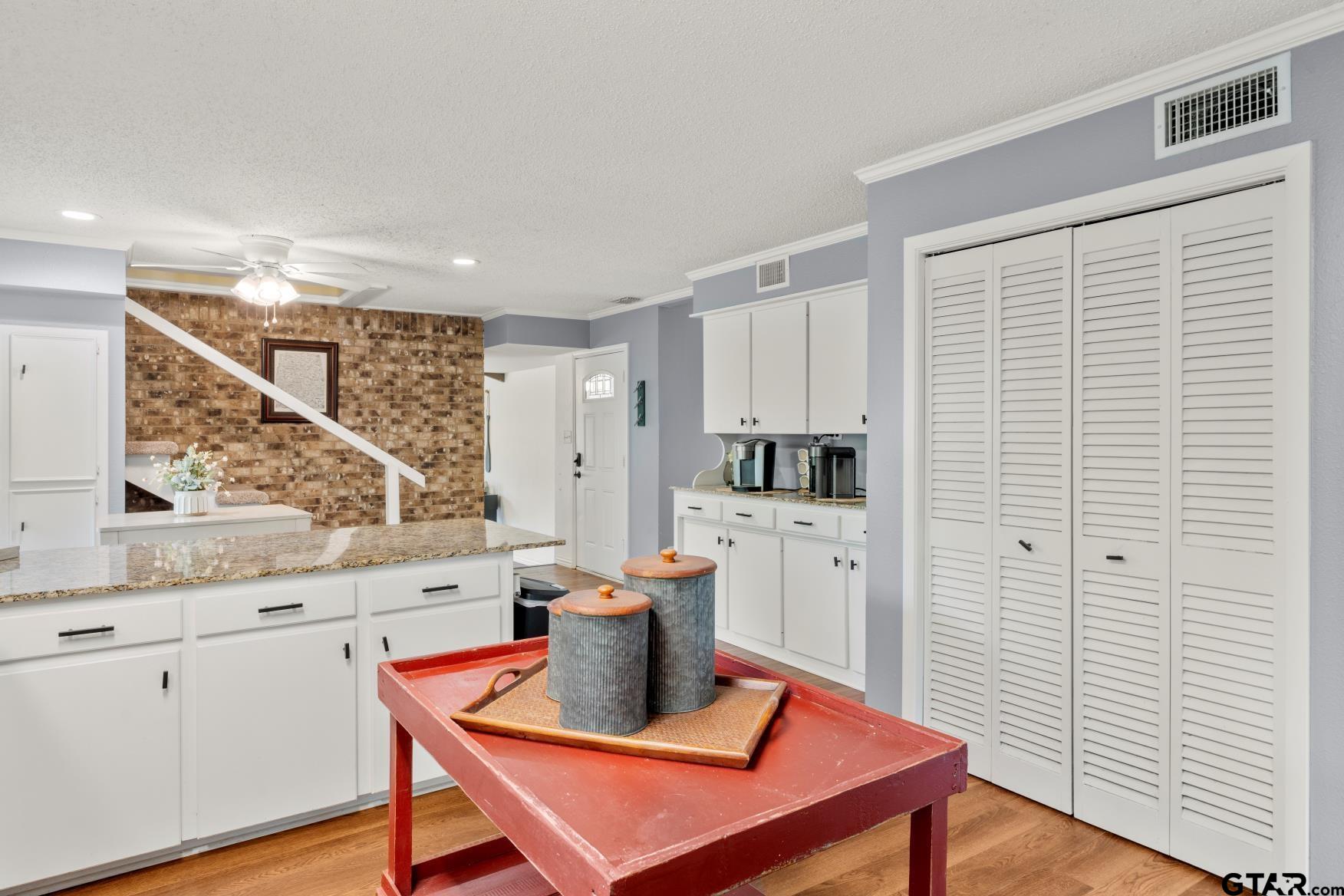 1614 County Road 2600 Mount Pleasant, TX 75455 - Photo 25 of 27 a kitchen with stainless steel appliances white cabinets a wooden floor and a window