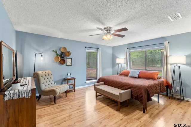 a bedroom with a bed wooden floor and a table