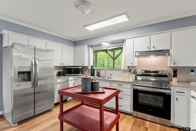 a kitchen with a stove a refrigerator and a stove top oven