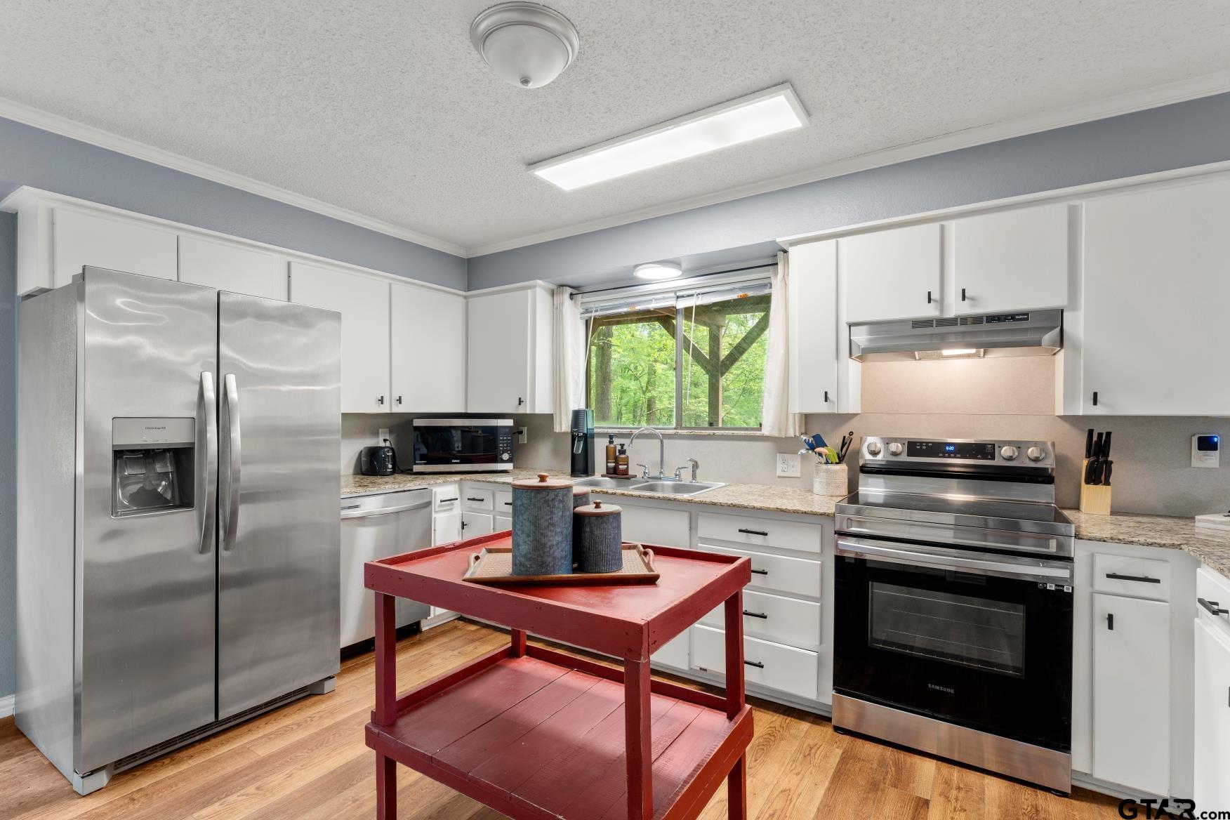 1614 County Road 2600 Mount Pleasant, TX 75455 - Photo 9 of 27 a kitchen with a stove a refrigerator and a stove top oven