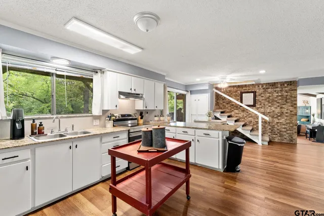a kitchen with a sink a counter top space appliances and a window