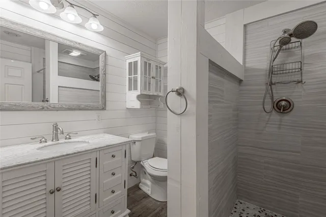 a bathroom with a sink a toilet and shower