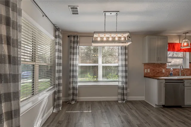 a kitchen with stainless steel appliances granite countertop a stove and a wooden floors