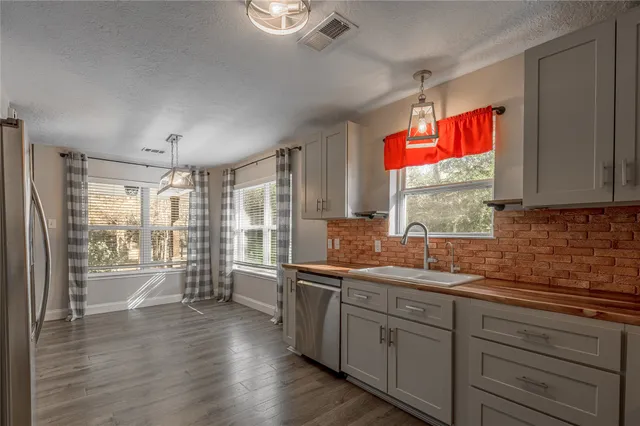 a kitchen with stainless steel appliances granite countertop a stove a sink and a refrigerator