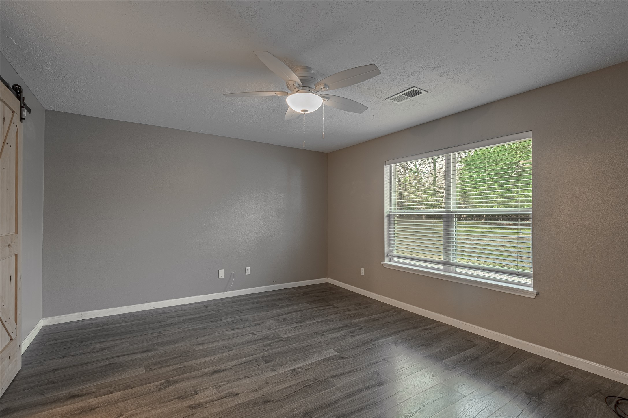 1022 Landing Way Trinity, TX 75862 - Photo 9 of 30 a view of an empty room with wooden floor and a window