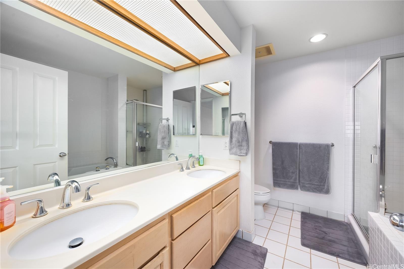 1305E Moanalualani Place, Unit 25C Honolulu, HI 96819 - Photo 13 of 21 a spacious bathroom with a sink and a mirror