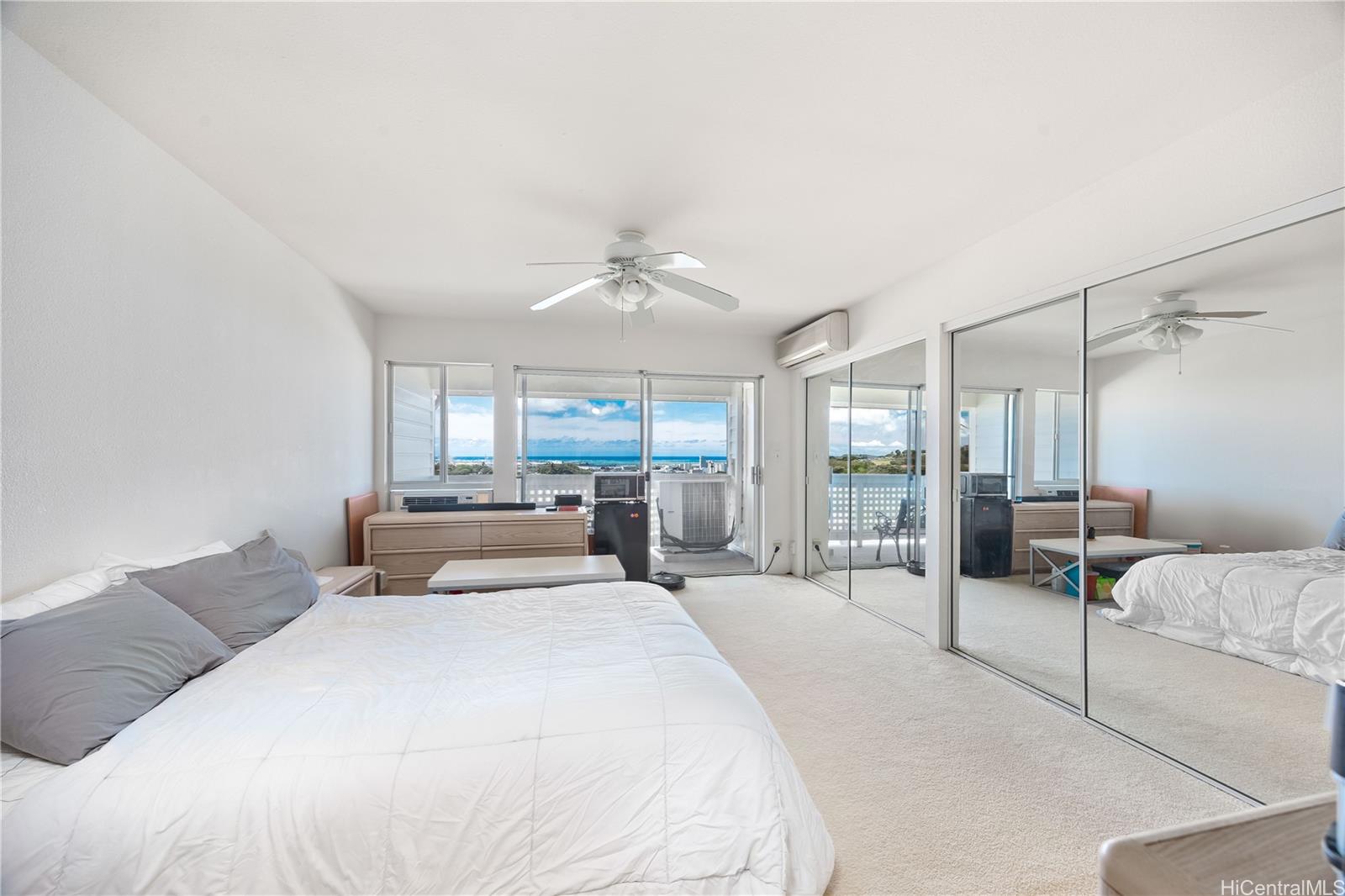 1305E Moanalualani Place, Unit 25C Honolulu, HI 96819 - Photo 10 of 21 a bedroom with a large bed and a chandelier