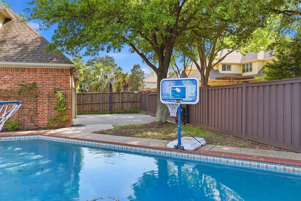 117 Portside Lane Coppell, TX 75019 - Photo 32 of 37 Resort-style backyard pairs poolside fun with a basketball setup for a rare blend of recreation and relaxation.