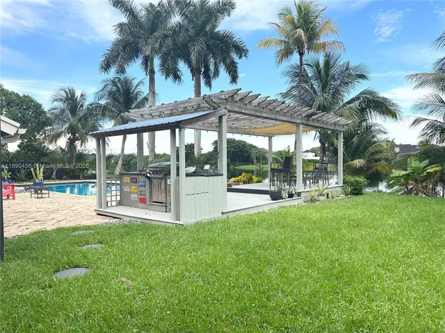 a view of backyard with swimming pool and patio