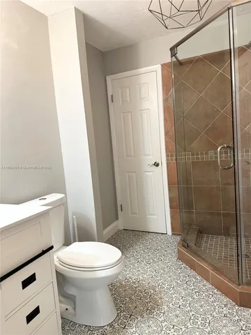 a bathroom with a toilet a sink and mirror