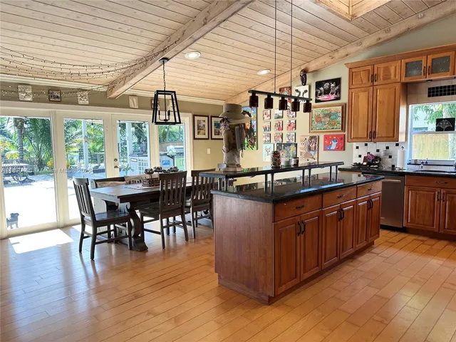 a kitchen with stainless steel appliances granite countertop wooden floors and white cabinets