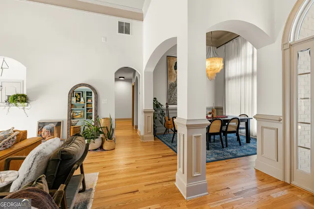 a dining room with furniture a chandelier and wooden floor