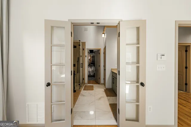 a view of a room with gym equipment and wooden floor