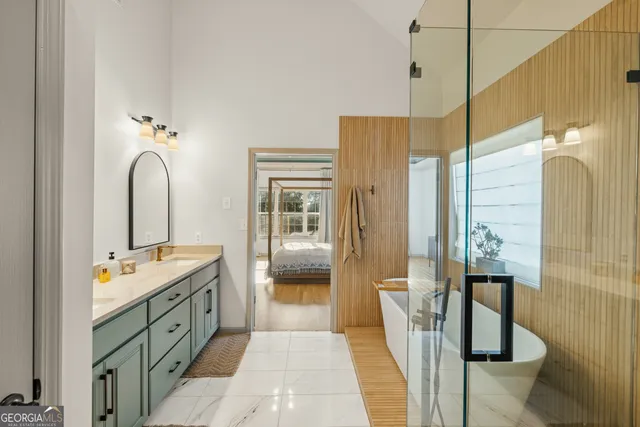 a bedroom with a bed a flat screen tv and a large window