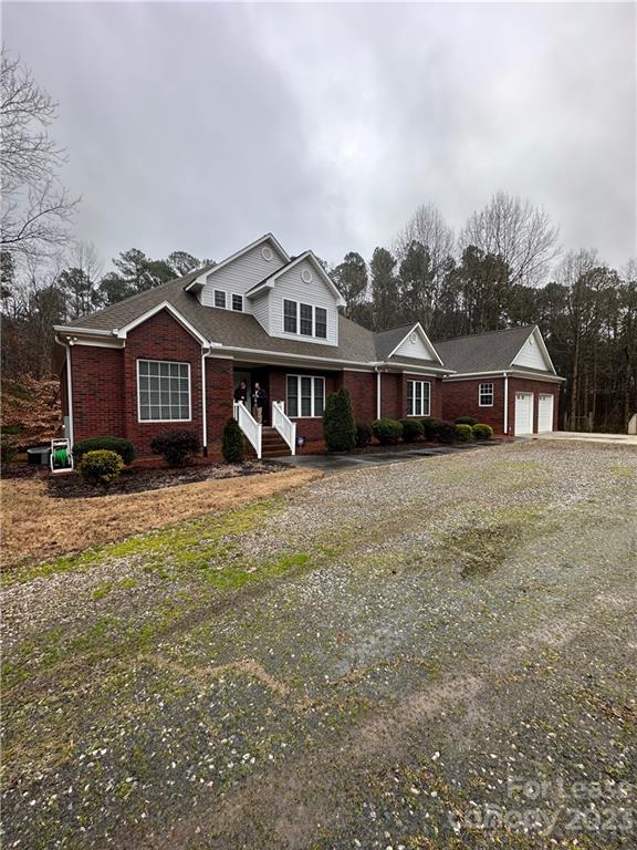 a front view of a house with a yard and lake view