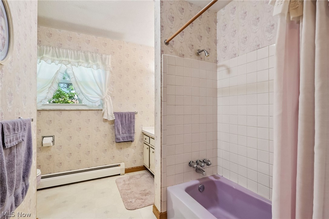 2428 Antioch Road Perry, OH 44081 - Photo 32 of 46 Upstairs bathroom with a window, white tile shower surround, and a purple bathtub