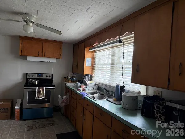 a kitchen with granite countertop a sink stove and cabinets