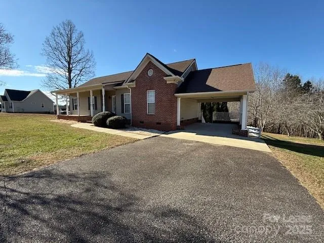 a view of a house with a yard and large tree