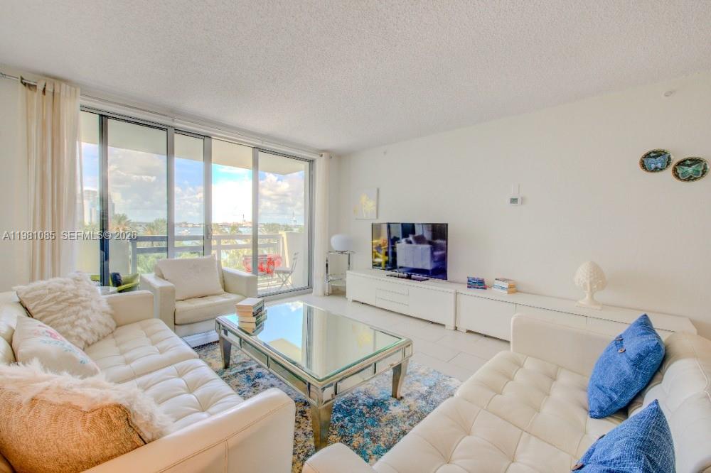 1500 Bay Road, Unit 528S Miami Beach, FL 33139 - Photo 2 of 11 a living room with furniture and a flat screen tv