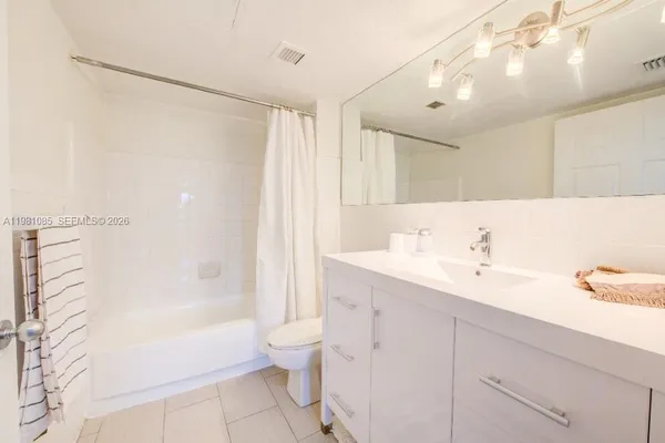 a bathroom with a bathtub shower sink vanity and toilet