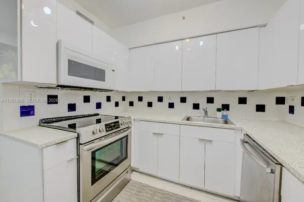 a kitchen with granite countertop cabinets and white stainless steel appliances