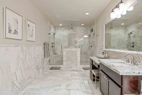 a bathroom with a granite countertop sink a toilet a mirror and shower