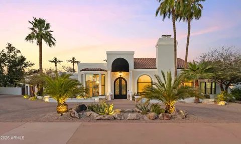 a front view of multi story residential apartment building with a yard and seating space