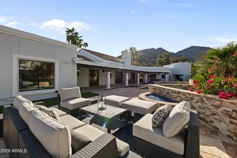 a view of house with patio outdoor seating and flowers