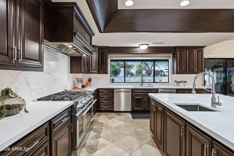 a kitchen with stainless steel appliances granite countertop a sink stove and refrigerator