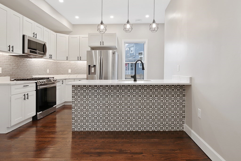 a kitchen with stainless steel appliances granite countertop a stove a sink and a microwave