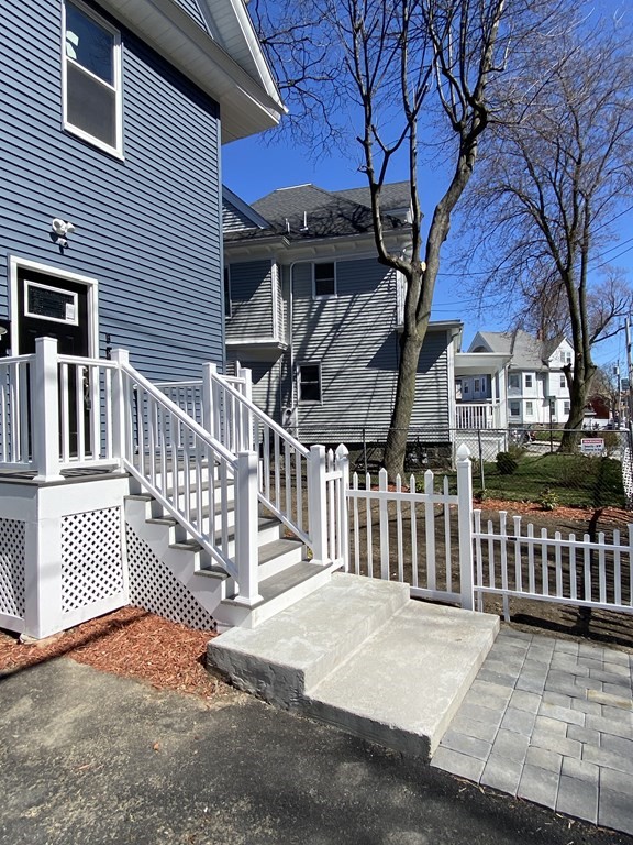 41 School Street, Unit 1 Boston, MA 02124 - Photo 24 of 25 a view of a house with a small yard and wooden fence