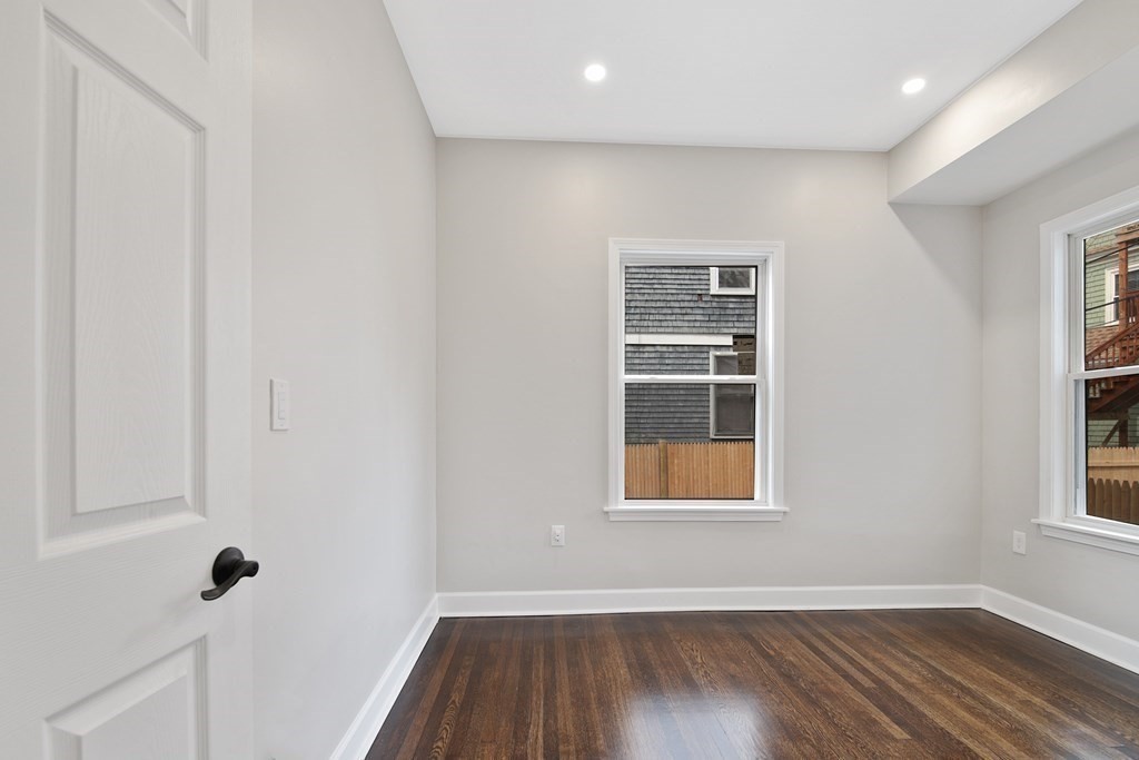41 School Street, Unit 1 Boston, MA 02124 - Photo 7 of 25 an empty room with wooden floor and windows