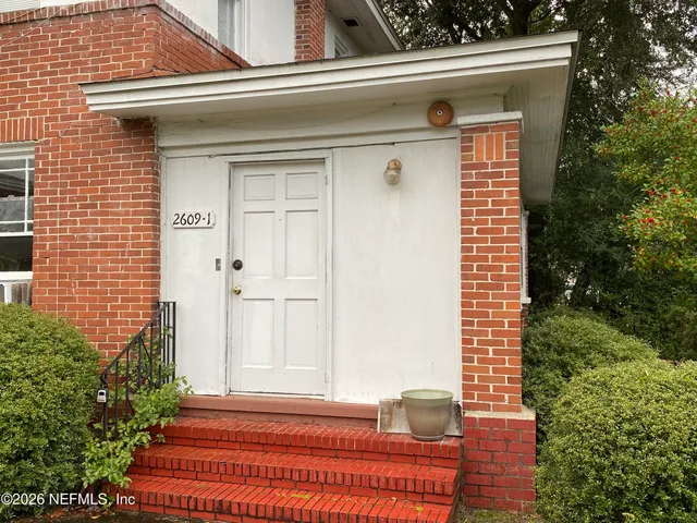 a view of wooden door and a window