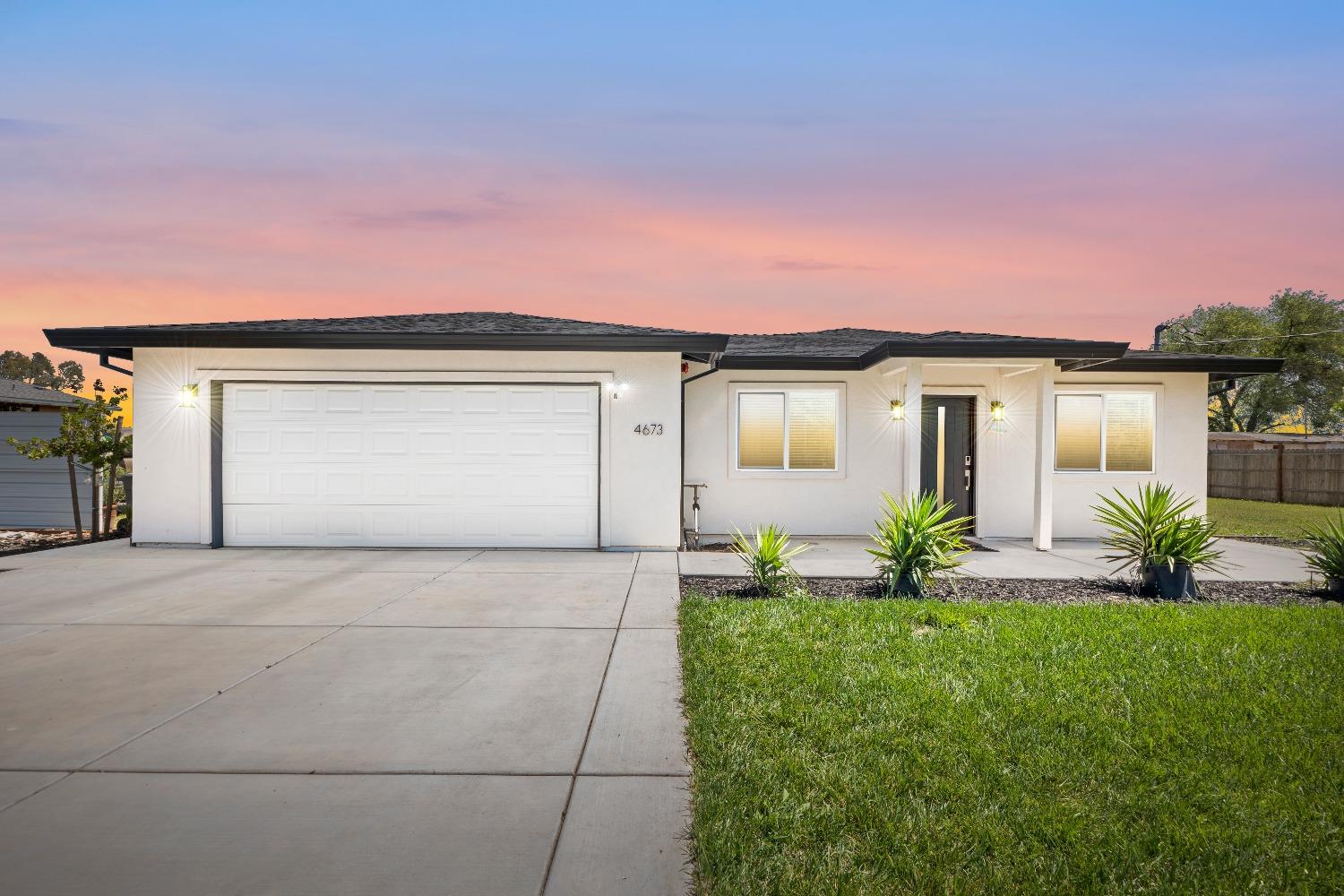 a front view of a house with a yard and a garage