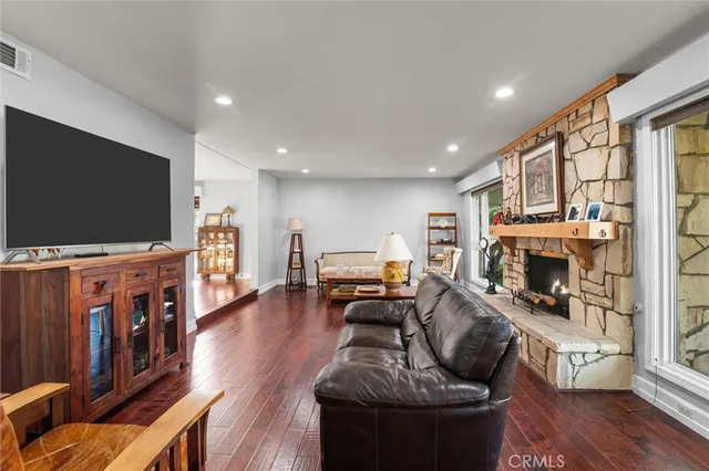 a living room with furniture fireplace and a large window